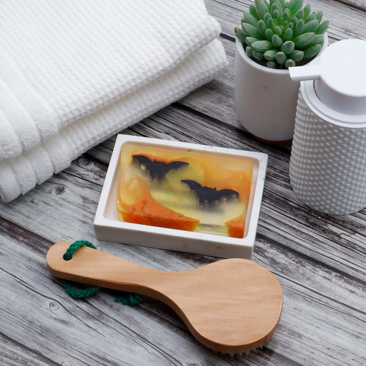 Bats glycerin bar soap featuring two black bats across a yellow moon with orange swirls in a translucent rectangular bar.
