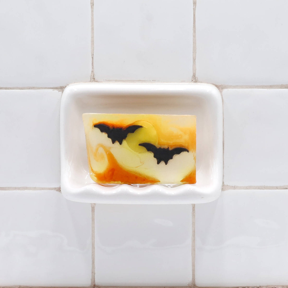 Bats glycerin bar soap featuring two black bats across a yellow moon with orange swirls in a translucent rectangular bar.