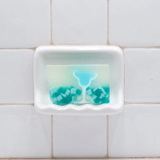 Blue Margarita Vegetable Glycerin Bar Soap in a white soap dish on a tiled bathroom wall