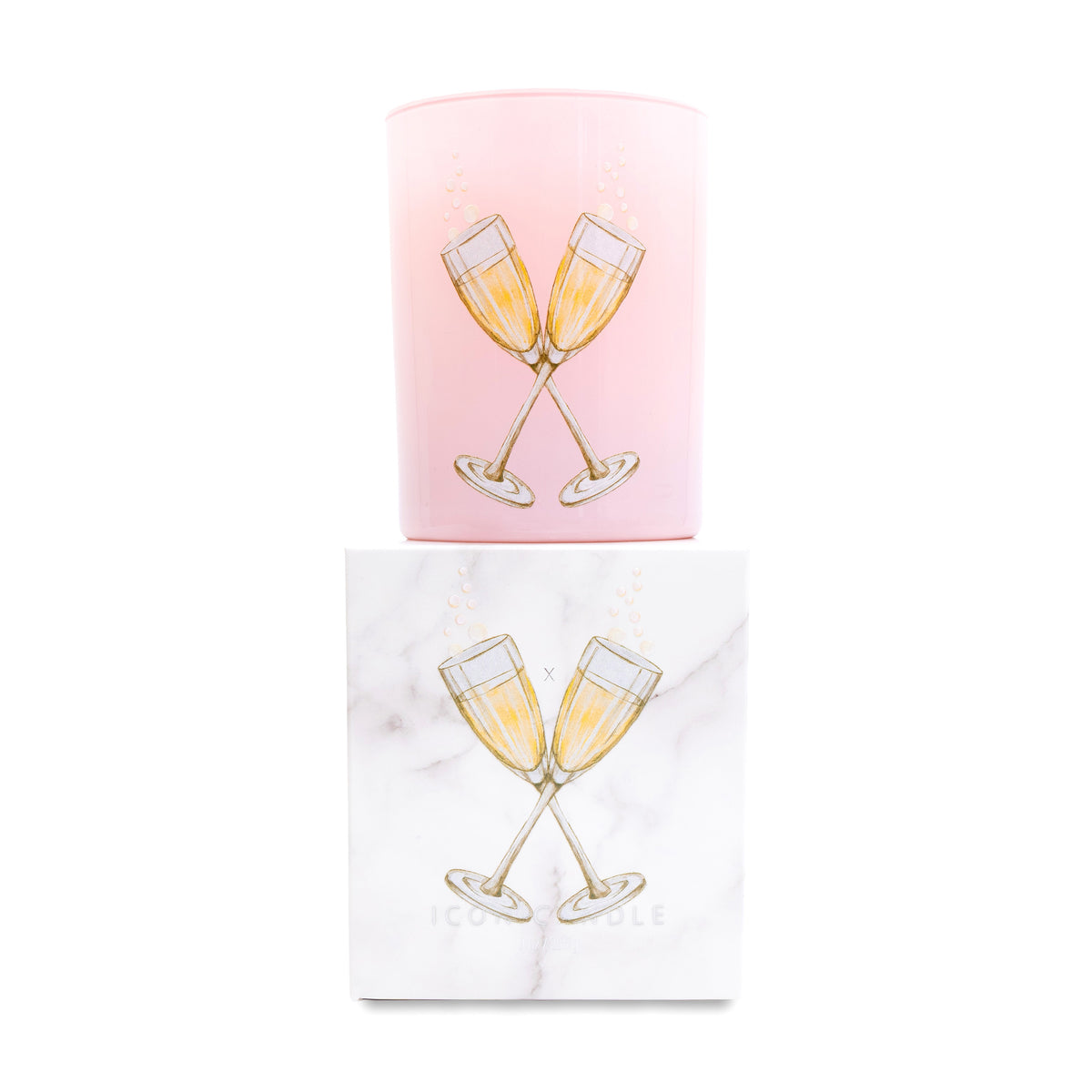 Pink glass candle with champagne glass design on top of a matching box on a white background