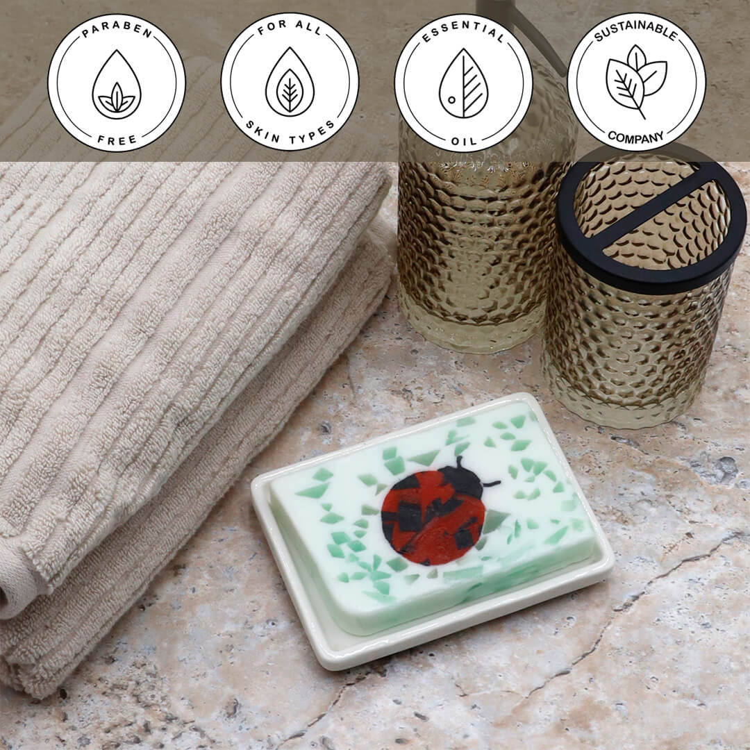 Ladybug Vegetable Glycerin Bar Soap in a white dish on a stone surface.