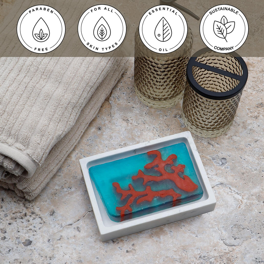 Red Coral Vegetable Glycerin Bar Soap in a white dish on a stone surface.