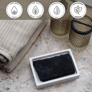 Bamboo Charcoal Vegetable Glycerin Bar Soap in a white dish on a stone surface.