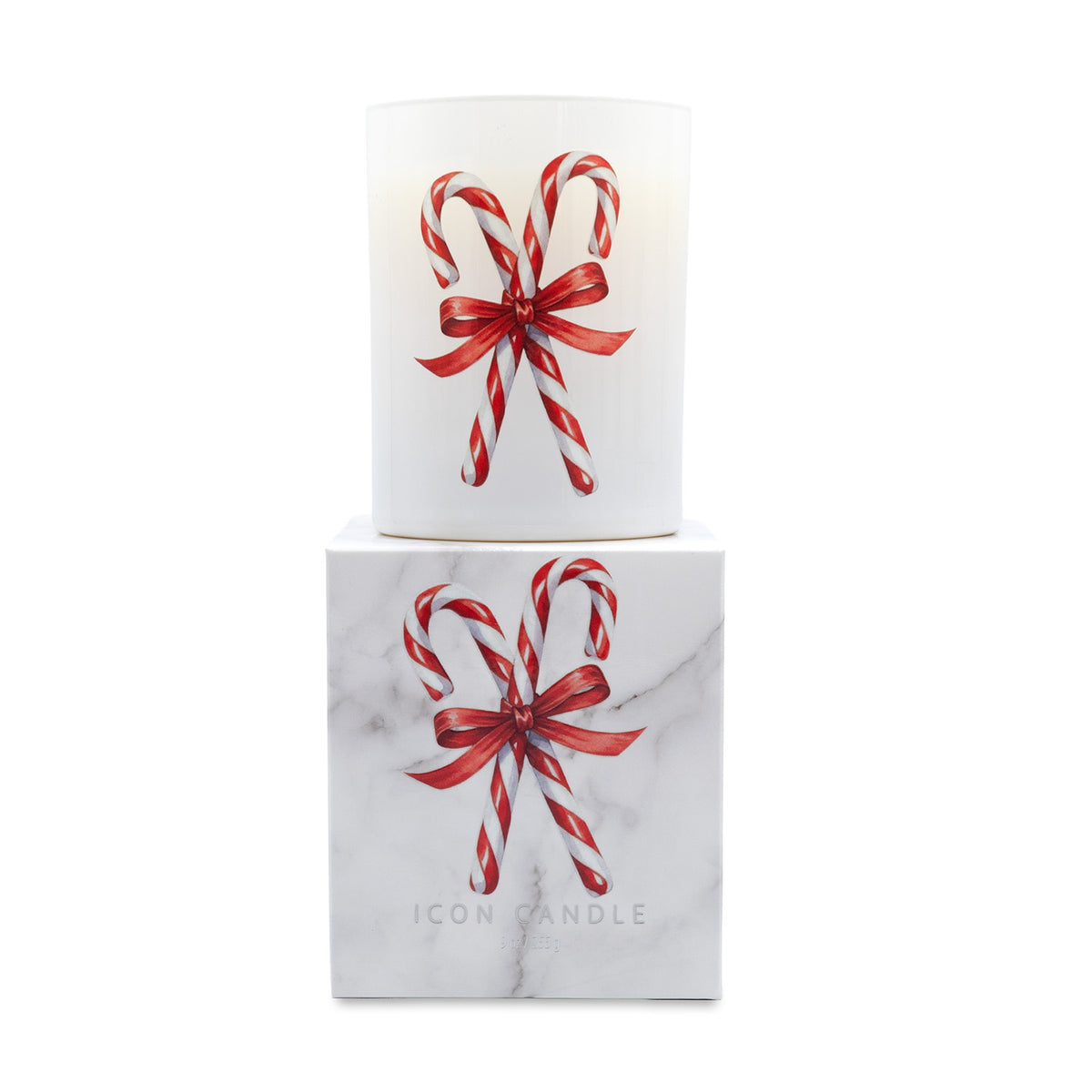 A white glass candle jar with a red and white candy cane bow illustration, displayed on top of its white marble-patterned box, which also features the same design and the brand name 'ICON CANDLE'.