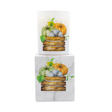 A white square candle box with a marble-like texture featuring an illustration of pumpkins in a wooden crate, with a matching white cylindrical candle displayed on top against a plain white background.