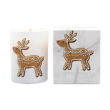 A white candle in a cylindrical glass vessel with a gingerbread deer illustration, shown next to its white marble-patterned box featuring the same deer design and the text 'ICON CANDLE'.