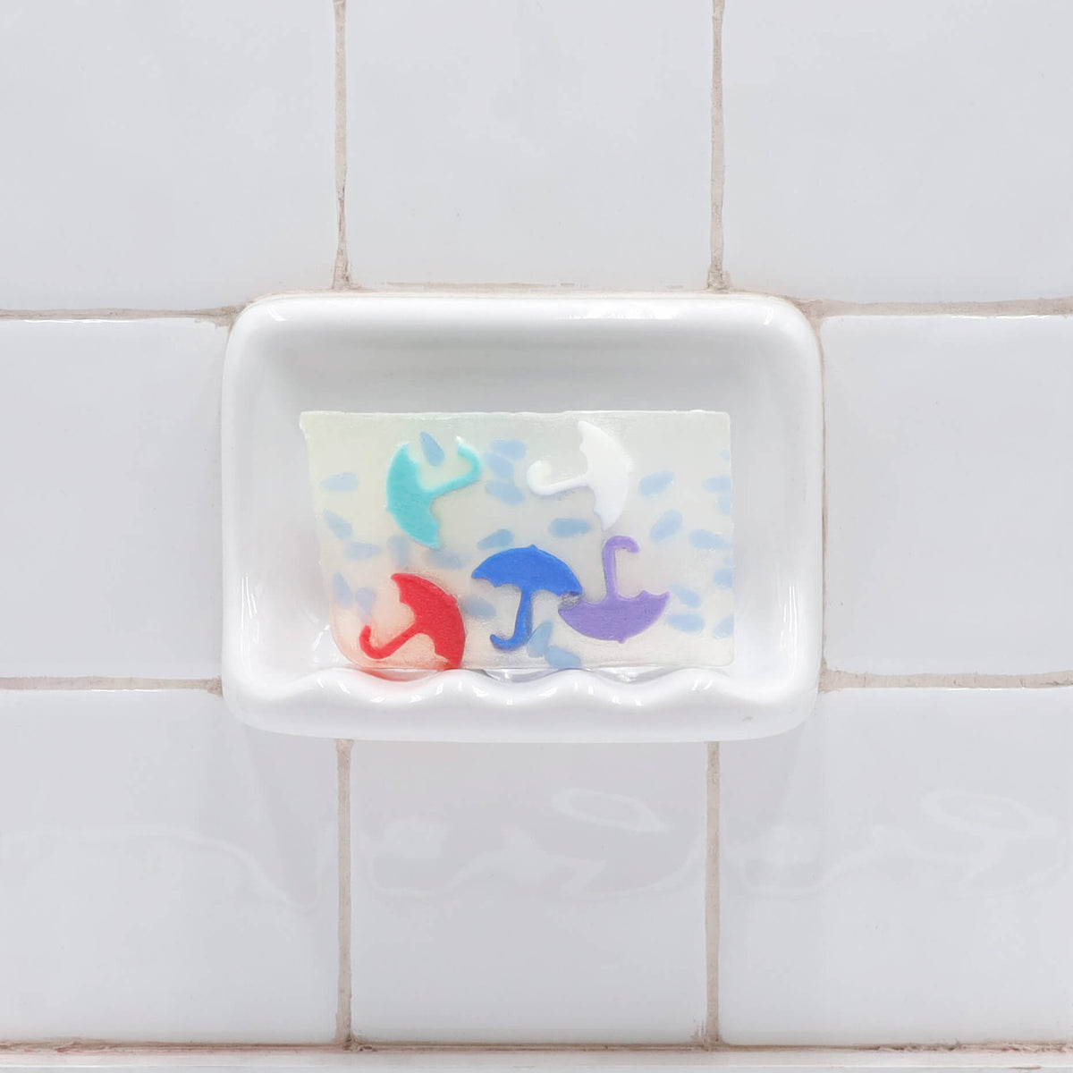 April Showers glycerin bar soap featuring colorful umbrellas and light blue raindrops in a translucent rectangular bar.