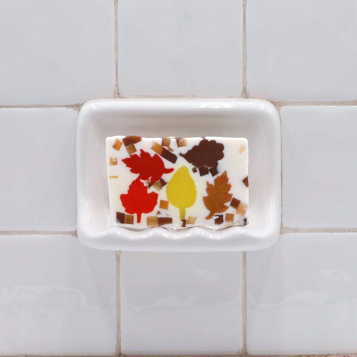 Autumn Leaves glycerin bar soap with red, yellow, amber, and brown leaf shapes surrounded by small autumn-colored soap pieces.