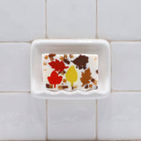Autumn Leaves glycerin bar soap with red, yellow, amber, and brown leaf shapes surrounded by small autumn-colored soap pieces.