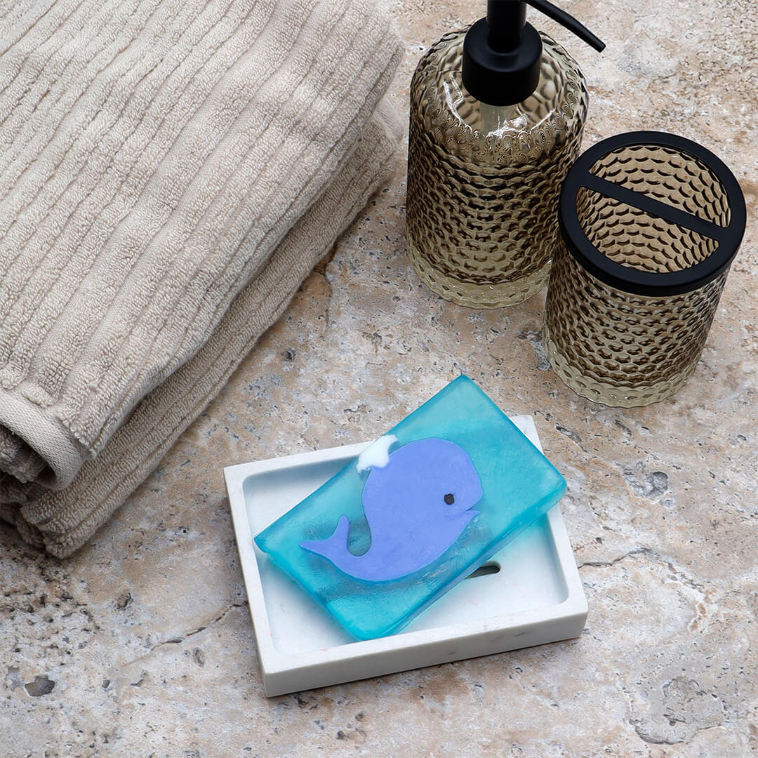 Blue Whale glycerin bar soap featuring a blue whale with a black eye and white waterspout in a translucent turquoise rectangular bar.