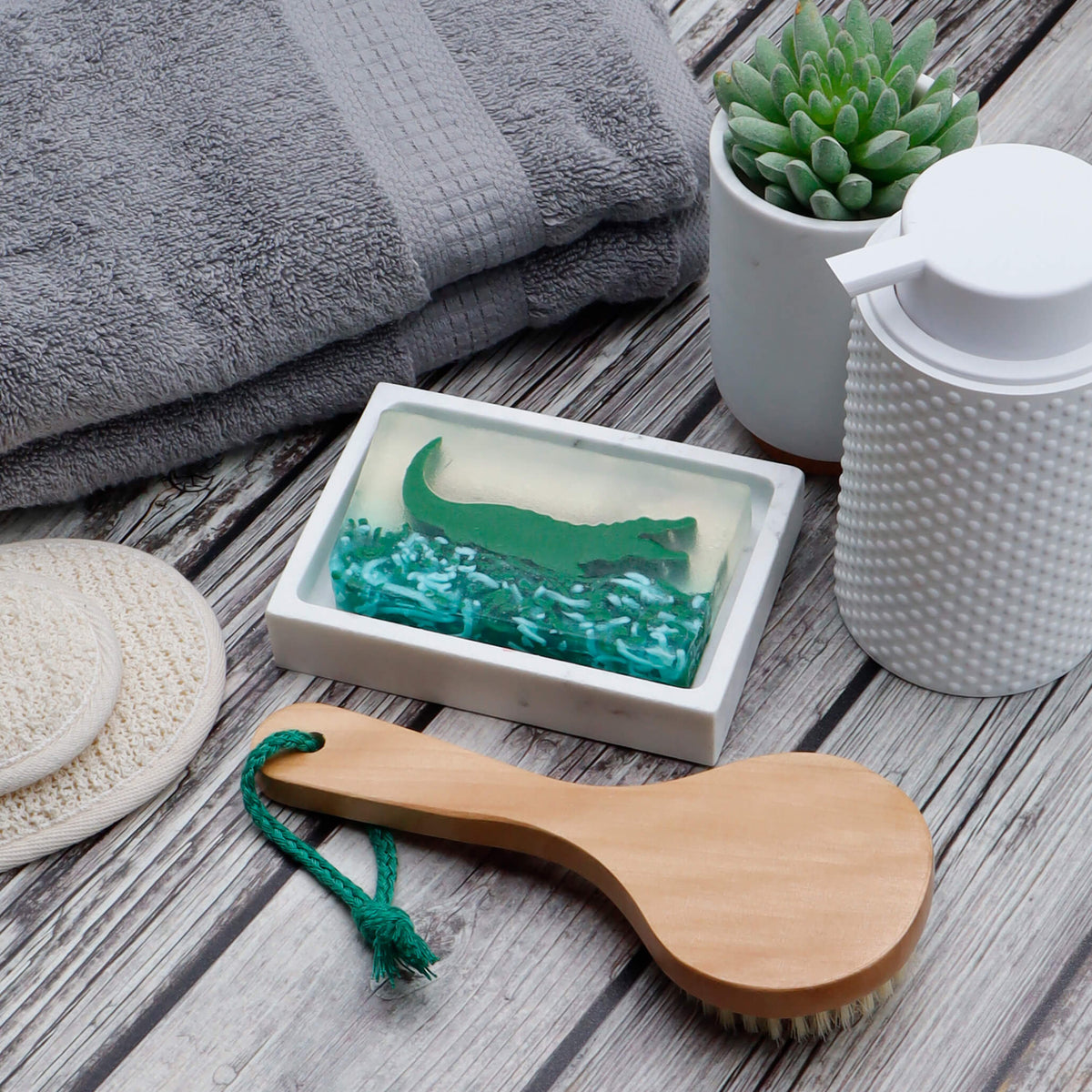 Alligator glycerin bar soap featuring a green alligator suspended in clear soap above textured green swamp-inspired details