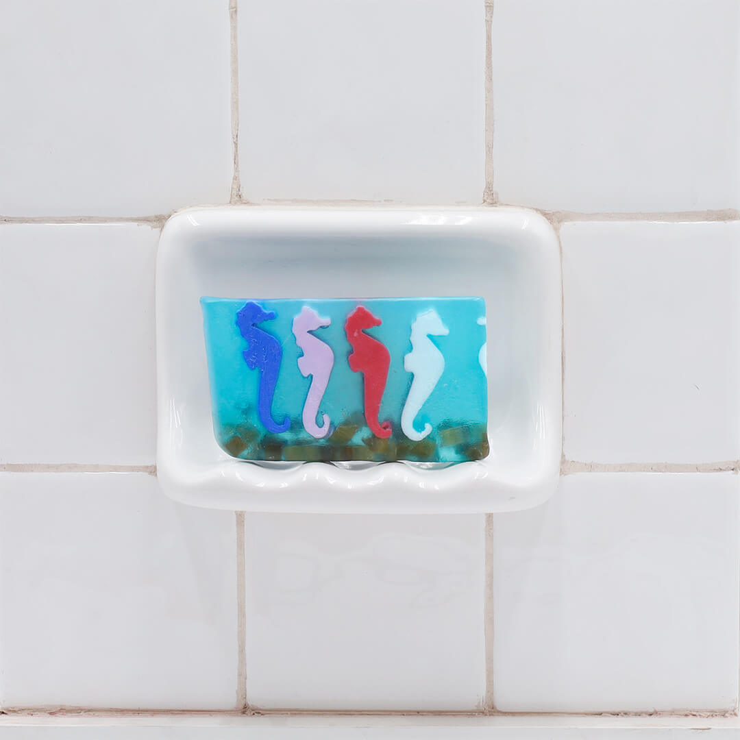 A Day at the Races aqua glycerin bar soap with colorful blue, pink, red, and white seahorses suspended in a translucent ocean-inspired design