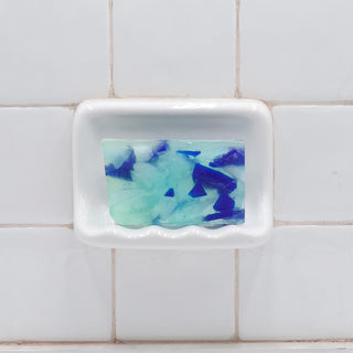 Beach Glass Vegetable Glycerin Bar Soap  in a white soap dish on a tiled bathroom wall