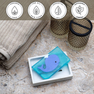 Blue Whale Vegetable Glycerin Bar Soap in a white dish on a stone surface.