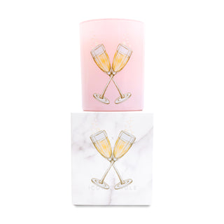 Pink glass candle with champagne glass design on top of a matching box on a white background