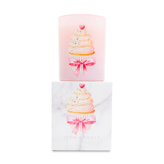 Pink candle with cupcake design and pink bow on top of matching white box on white background
