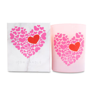 Pink candle with heart design and matching white box on a white background