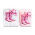 Pink cowboy boots and hat candle next to a matching white box on a white background.