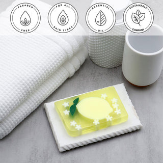 California Lemon Vegetable Glycerin Bar Soap in a white dish on a stone surface.