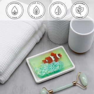 Clownfish Vegetable Glycerin Bar Soap in a white dish on a stone surface.