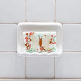 Butterfly glycerin bar soap featuring an ivory butterfly with an orange body surrounded by pink, teal, and pale green soap pieces.