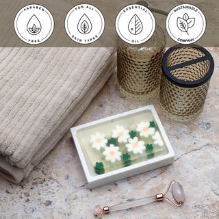 Daisy Vegetable Glycerin Bar Soap in a white dish on a stone surface.