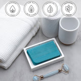 Dead Sea Mud Vegetable Glycerin Bar Soap in a white dish on a stone surface.