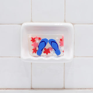 Flip Flops Vegetable Glycerin Bar Soap in a white soap dish on a tiled bathroom wall.