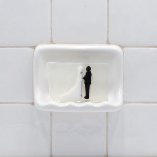 Holy Matrimony Vegetable Glycerin Bar Soap in a white soap dish on a tiled bathroom wall.