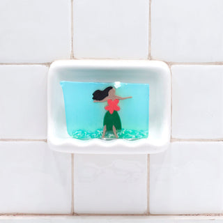 Hula Girl Vegetable Glycerin Bar Soap in a white soap dish on a tiled bathroom wall.