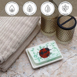 Ladybug Vegetable Glycerin Bar Soap in a white dish on a stone surface.