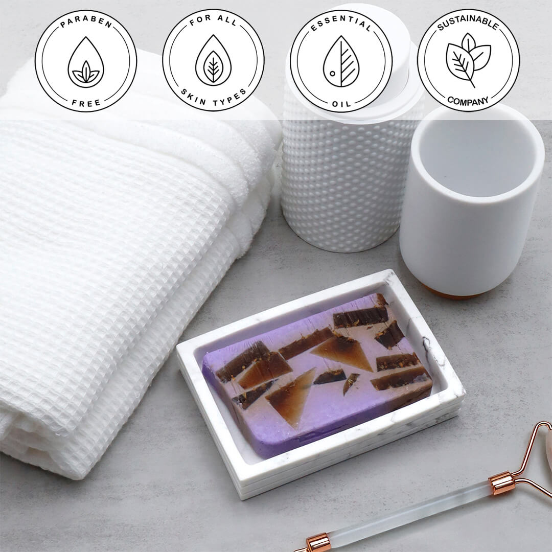 Lavender Essential Oil Vegetable Glycerin Bar Soap in a white dish on a stone surface.
