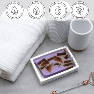 Lavender Essential Oil Vegetable Glycerin Bar Soap in a white dish on a stone surface.