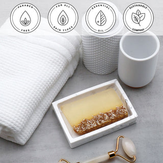 Lavender Oatmeal Vegetable Glycerin Bar Soap in a white dish on a stone surface.