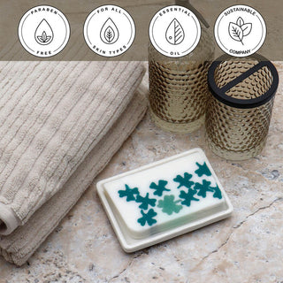 Lil' Bit of Luck Vegetable Glycerin Bar Soap in a white dish on a stone surface.