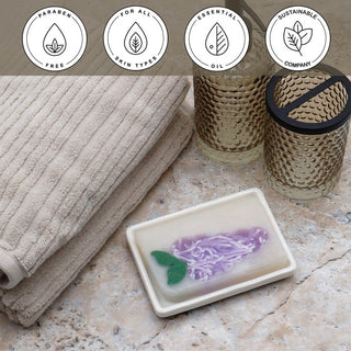 Lilac Vegetable Glycerin Bar Soap in a white dish on a stone surface.