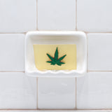 Pot Leaf Vegetable Glycerin Bar Soap in a white soap dish on a tiled bathroom wall.
