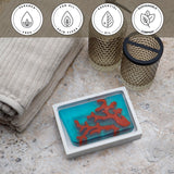 Red Coral Vegetable Glycerin Bar Soap in a white dish on a stone surface.