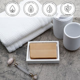 Rhassoul Clay Vegetable Glycerin Bar Soap in a white dish on a stone surface.
