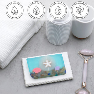 Sand Dollar Vegetable Glycerin Bar Soap in a white dish on a stone surface.