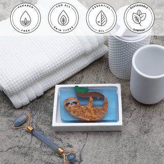 Swinging Sloth Vegetable Glycerin Bar Soap in a white dish on a stone surface.