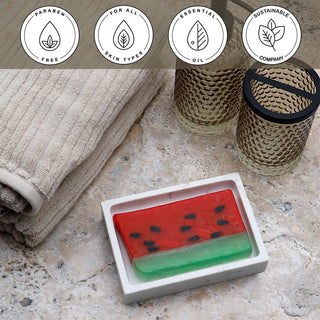 Watermelon Vegetable Glycerin Bar Soap in a white dish on a stone surface.